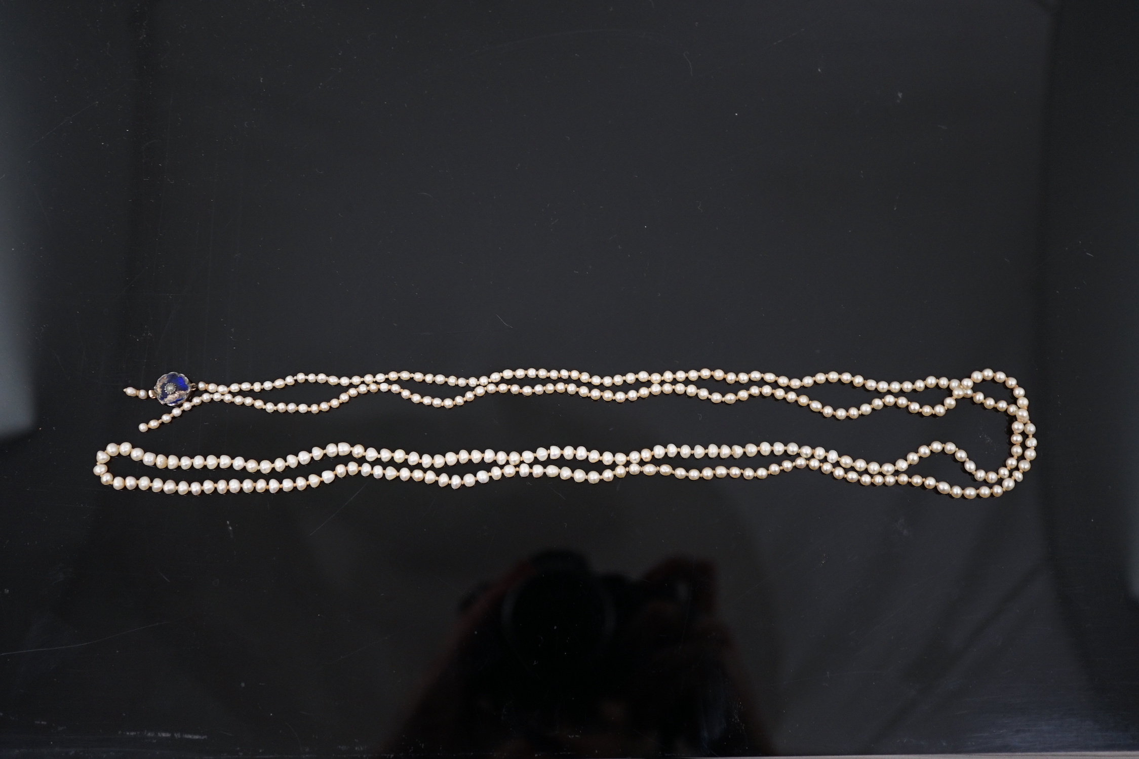 A Victorian single strand graduated natural saltwater pearl necklace, with seed pearl and enamel set gold clasp